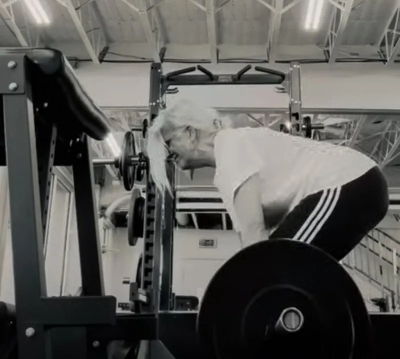 Older athlete performing a deadlift in a commercial gym